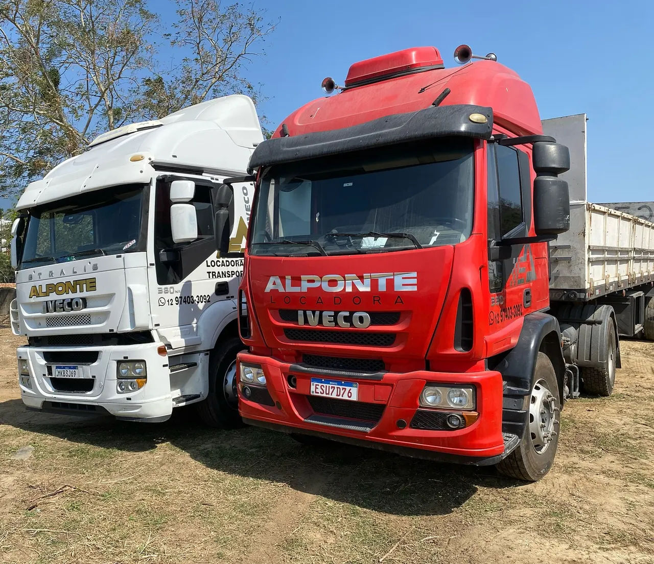 Dois cavalos mecânicos Iveco da Locadora Alponte, um branco e um vermelho, lado a lado no pátio